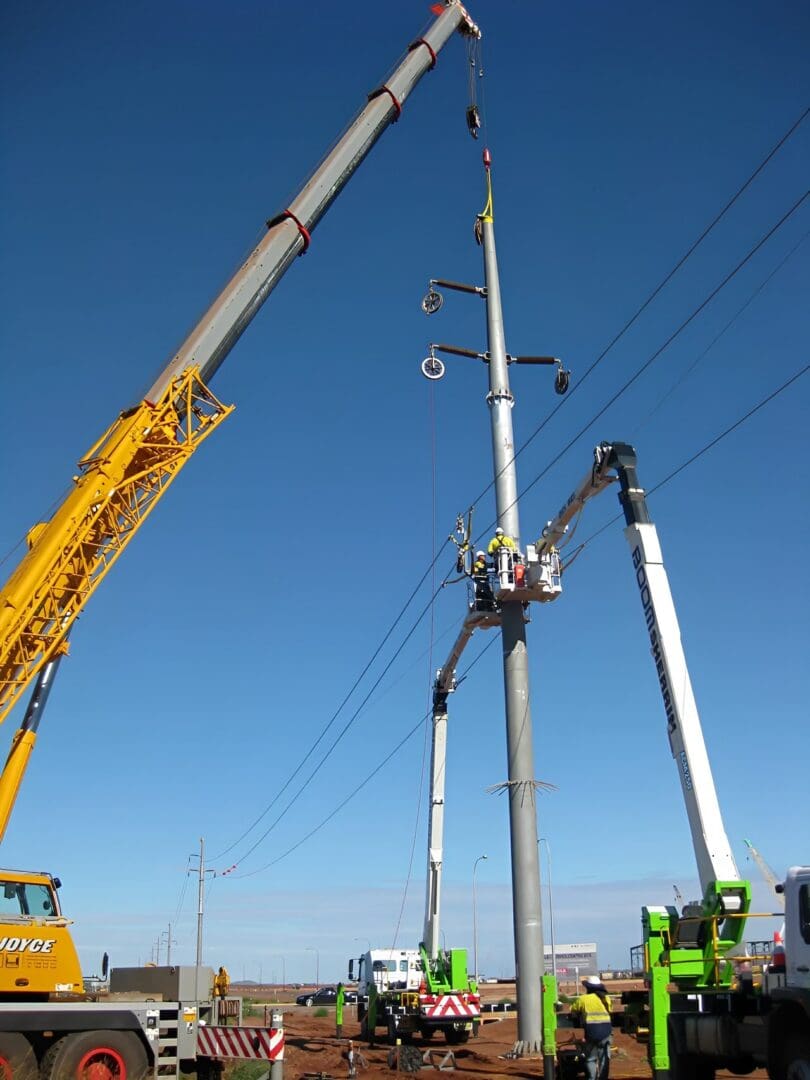 Construction site with cranes and electric pole.