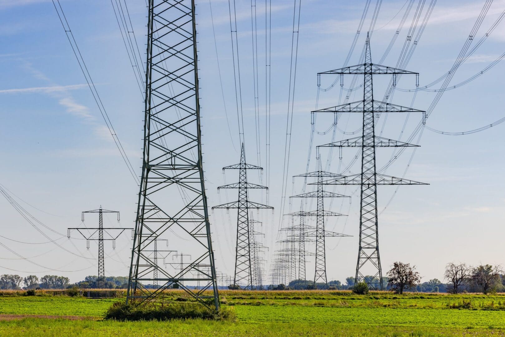 Rows of transmission towers across green fields