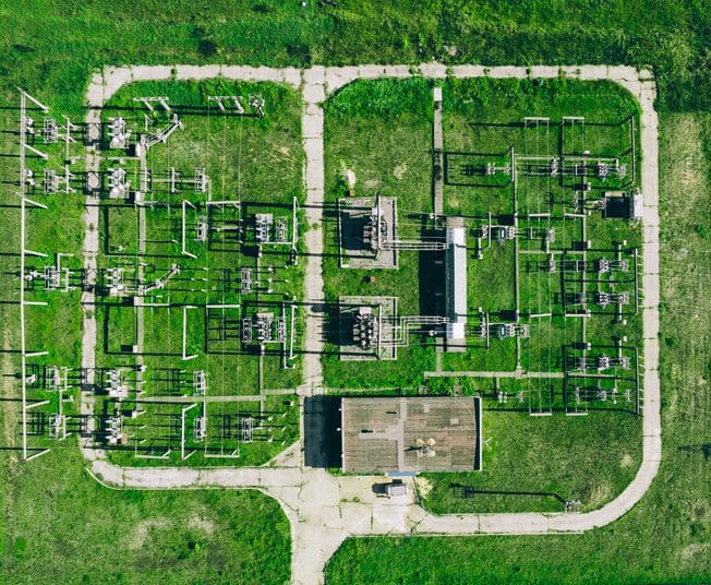 Aerial view of electrical substation in grassy field