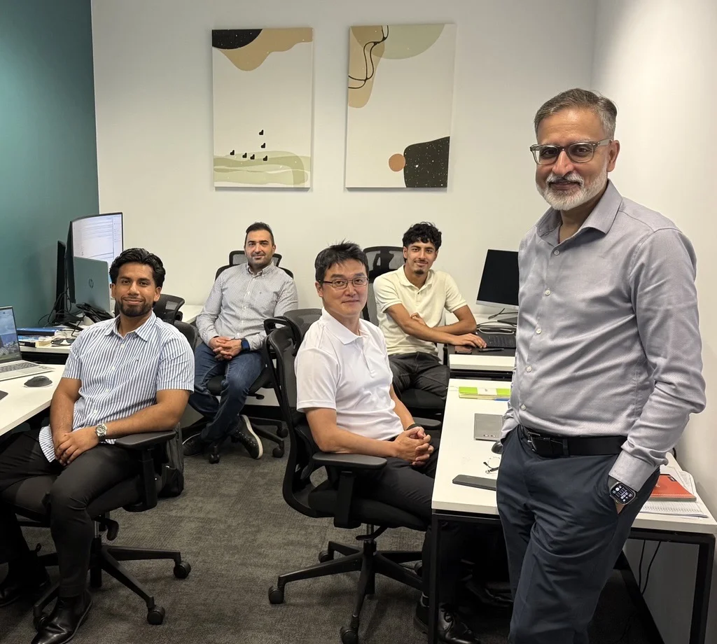 Five men in office smiling at camera