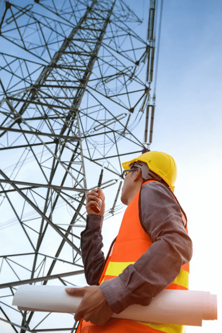 Construction worker with radio by transmission tower