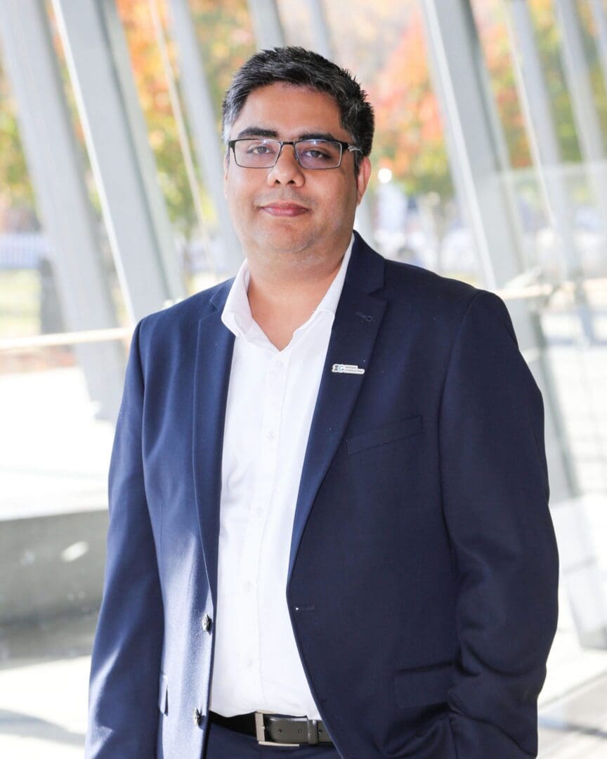 Person wearing navy suit and glasses